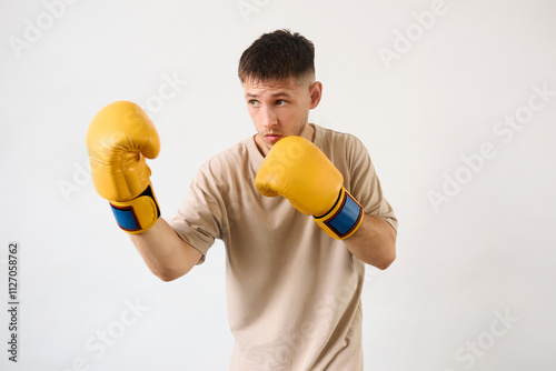 Handsome young guy shows defense technique with boxing gloves