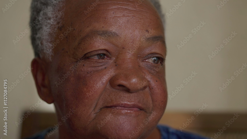 Close-up face of a pensive black senior woman. Contemplative African American elderly person with thoughtful emotion Close-up face of a pensive black senior woman. Contemplative African American elderly person with thoughtful emotion