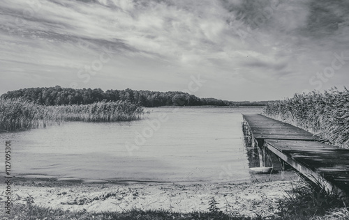 Beautiful, deserted beach and jetty in Poland in midsummer. Lonely idyll without people in the great outdoors. Wooden pier on the beach and pier for boats. Fantastic nature in deserted paradiese. photo