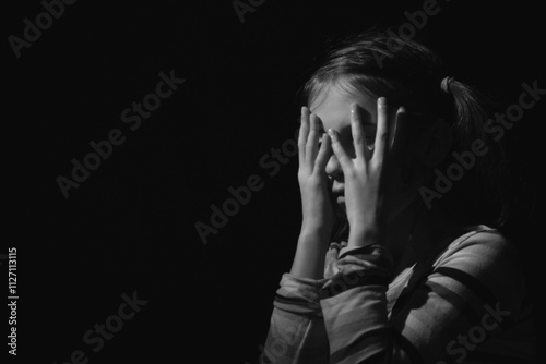 Portrait of stressed, unhappy young adolescent girl crying and feeling exhausted or depressed alone. Black and white image. Copy space.