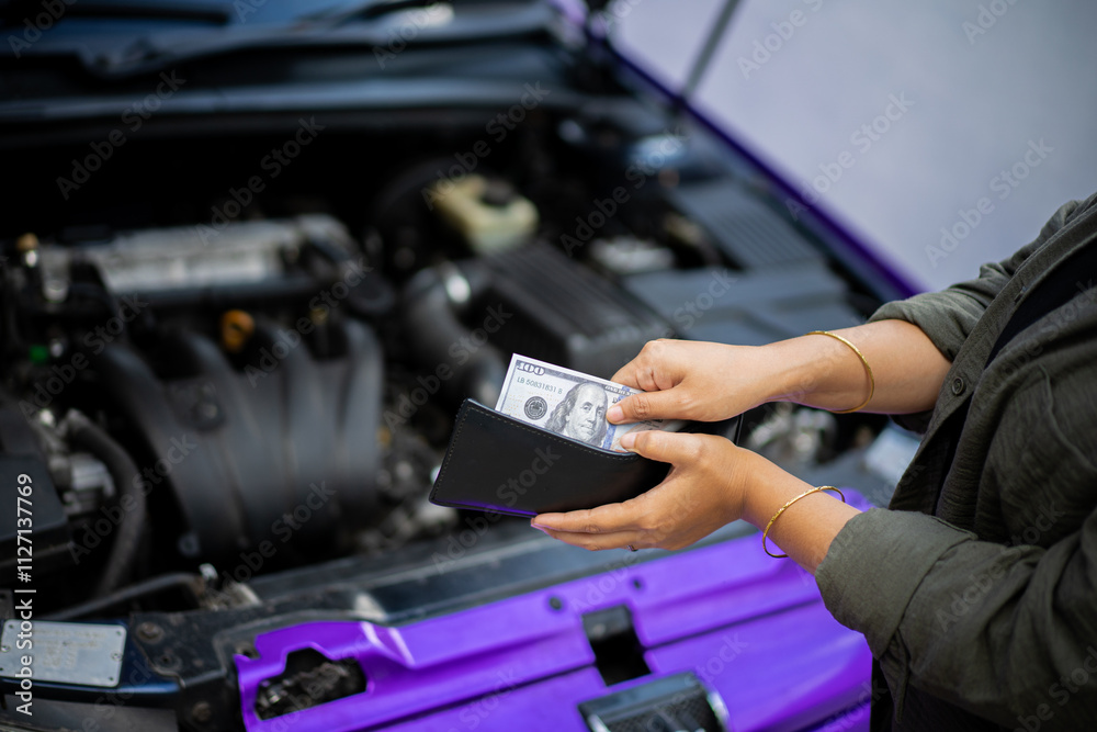 Young Indonesian woman wearing hijab spends money to pay for car repairs, automotive industry concept. Young Indonesian woman wearing hijab spends money to pay for car repairs, automotive industry concept.
