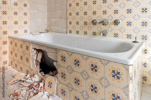 Debris and broken tiles scattered on bathroom floor during home renovation photo