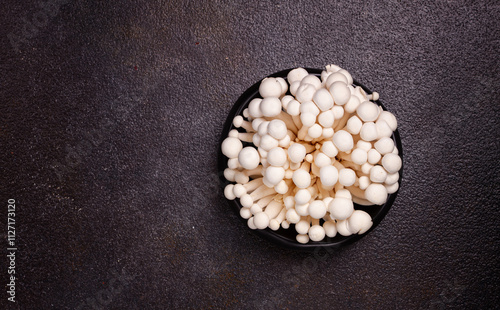 fresh white shimeji mushrooms, on a black plate, no people. photo