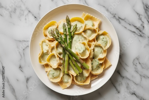a plate of cappelletti pasta drenched in a creamy asparagus sauce