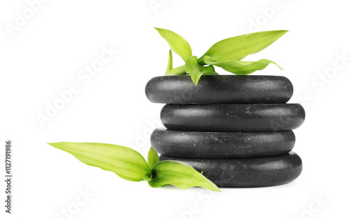 Spa stones and green leaves isolated on white