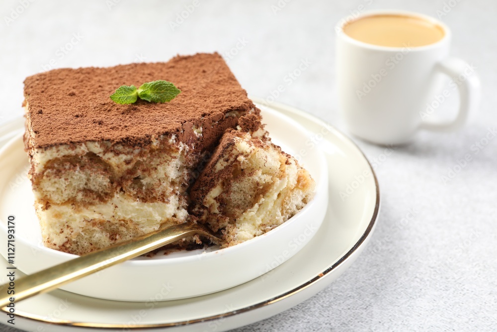 Delicious tiramisu with mint on light table, closeup Delicious tiramisu with mint on light table, closeup