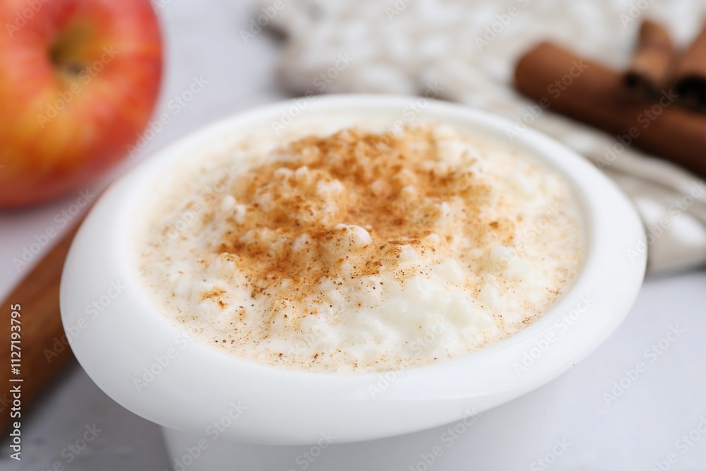 Delicious rice pudding with cinnamon on table, closeup