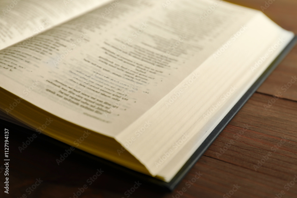Fototapeta premium Open Holy Bible in English language on wooden table, closeup