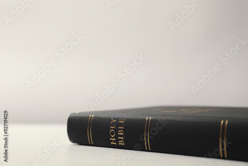 Hardcover Holy Bible on white table, closeup. Space for text photo