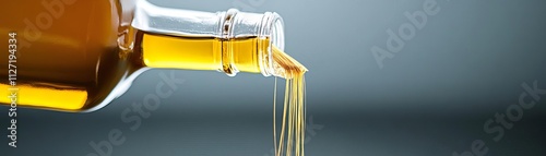 Fractured olive oil bottle pouring golden threads photo