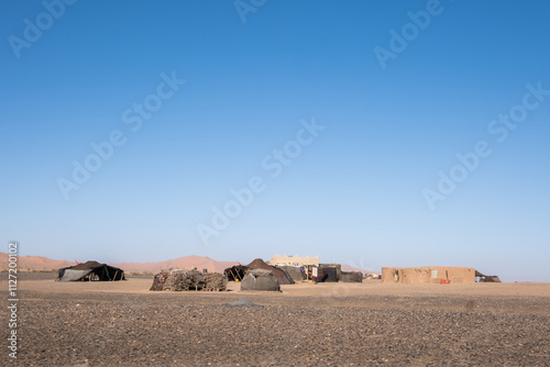 A nomad camp in the middle of the Sahara desert in Morocco, North Africa. Nomadic people in extinction. Safety, survival and life in the hostile nature of the desert. There are tents made of fabric