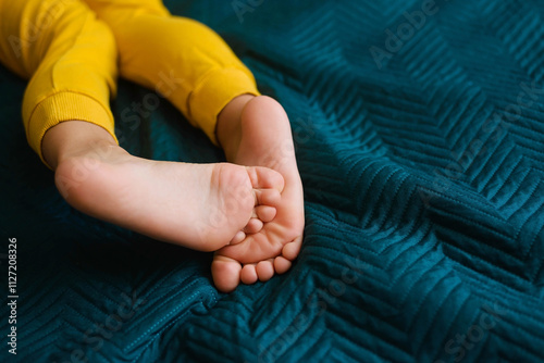 Children's feet and heels on a dark blue bed. Importance of sleep for babies. Sleep mode babies 5 y.o
