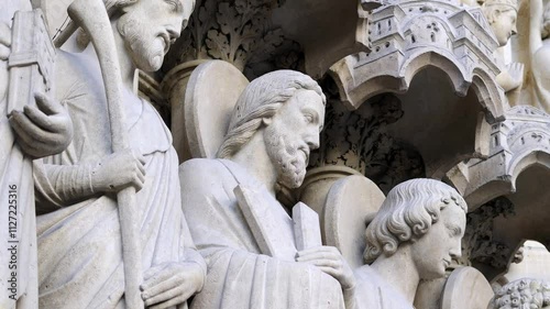 Intricate stone carvings of saints on the facade of Notre Dame Cathedral in Paris, showcasing Gothic architecture and religious art