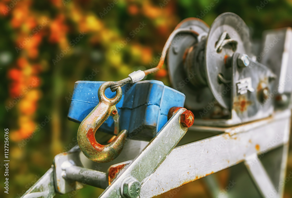 Close-up of a winch with a large, metal hook.
Capstan winch for transporting boats. Close-up of a winch with a large, metal hook.
Capstan winch for transporting boats.