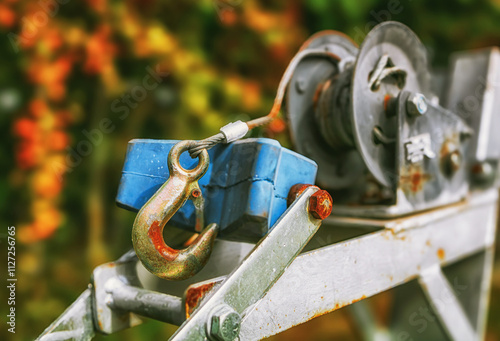 Close-up of a winch with a large, metal hook. Capstan winch for transporting boats.