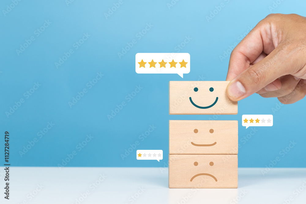Service rating, satisfaction and positive feedback concept. A man choose smile face emoticon give a five star rating indicates the highest level of satisfaction Service rating, satisfaction and positive feedback concept. A man choose smile face emoticon give a five star rating indicates the highest level of satisfaction