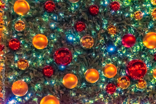 Wallpaper Mural A close-up of festive Christmas tree decorations on the facade of Galeria Canalejas, Madrid, Spain, 2021. Tree is adorned with bright red and gold baubles, glowing lights, and vibrant holiday spirit Torontodigital.ca