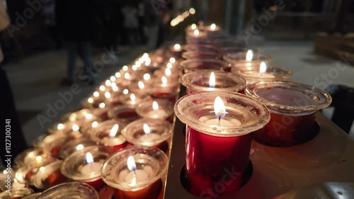 Lit candles inside the Cathedral of Santiago de Compostela, offering a spiritual and peaceful ambiance.
