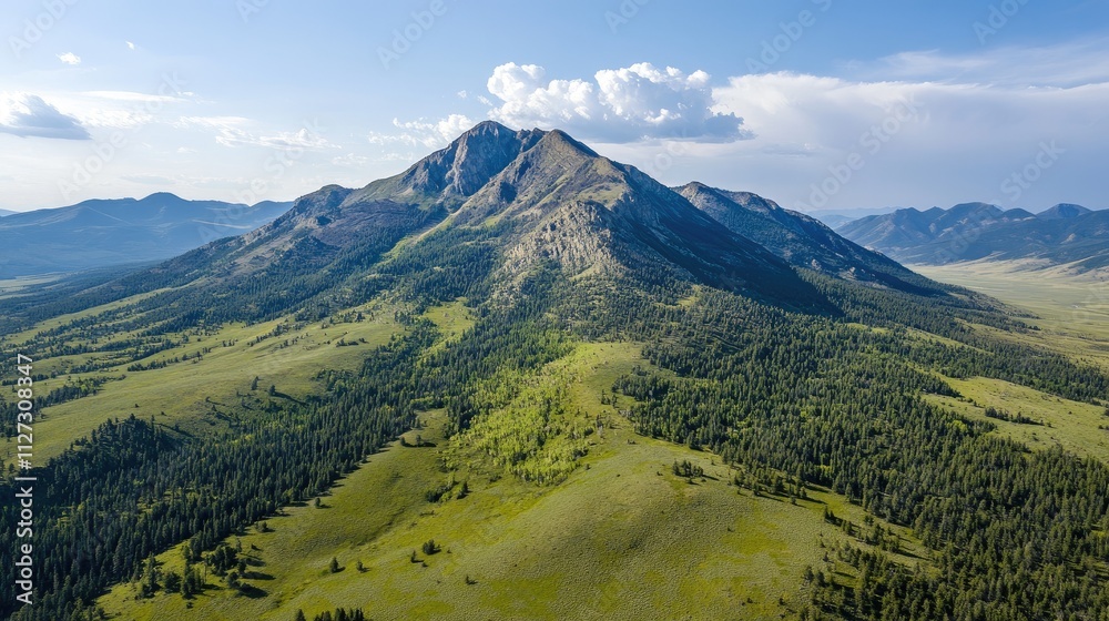 Aerial view of majestic mountain peak surrounded by lush green valleys and clear blue skies in a serene natural landscape. Aerial view of majestic mountain peak surrounded by lush green valleys and clear blue skies in a serene natural landscape.