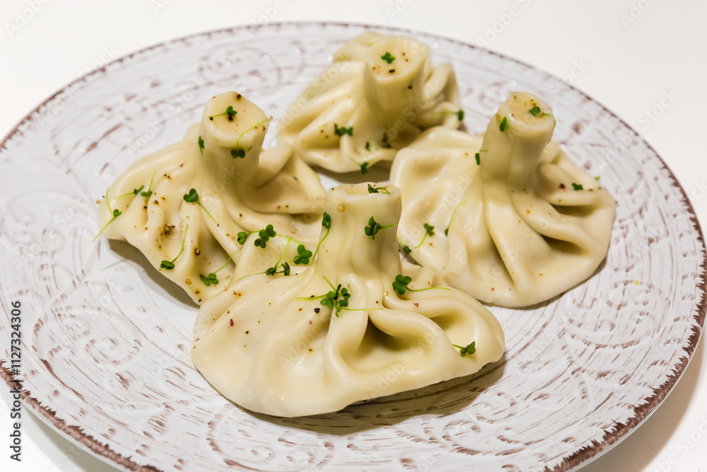 Boiled khinkali on white-brown dish on white table Boiled khinkali on white-brown dish on white table