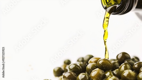 Pouring green capers with olive oil on a white background showcasing culinary ingredients for gourmet dishes and healthy cooking concepts photo