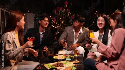 Group of friends clinking glasses in celebration at night, Happy group of friends having celebration and drinking dinner party at night, Holiday, Festival celebration.