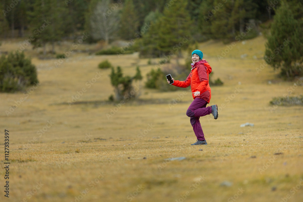 A woman in a red jacket is running in a field A woman in a red jacket is running in a field