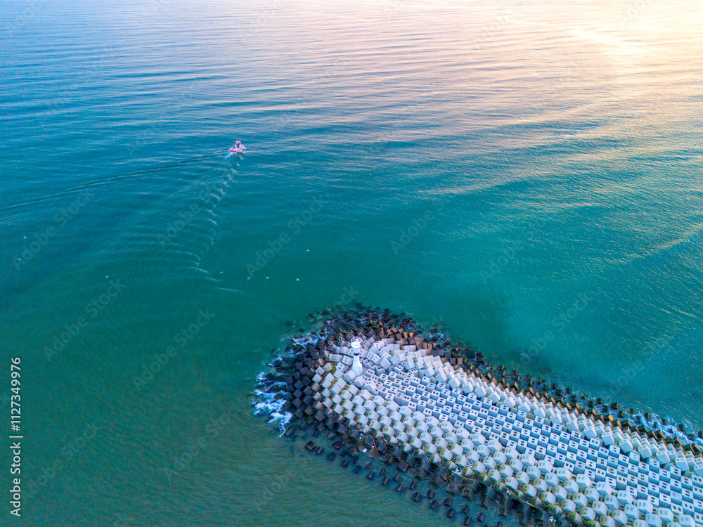Obraz premium Sakarya High-angle, full shot of a tranquil coastal scene. Aerial View of Coastal Breakwater with Small Boat on Calm Turquoise Water. Karasu Adapazari Turkiye Drone Shot Turkey Holiday travel photo 