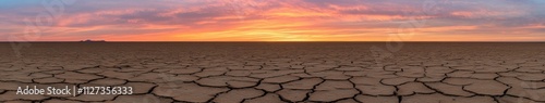 Vibrant sunset over a cracked desert landscape photo