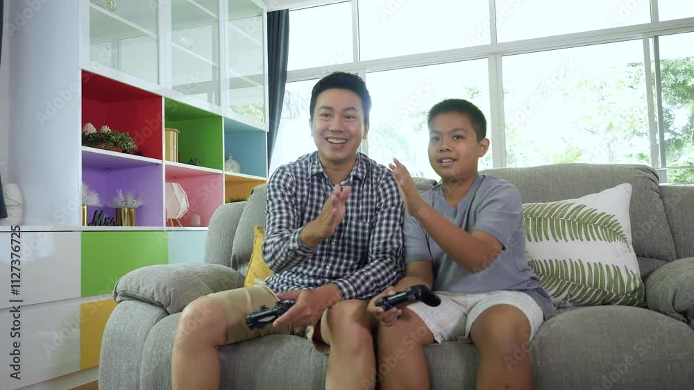 Happy Asian family playing video games and give Hi Five at home. Happy Asian family playing video games and give Hi Five at home.