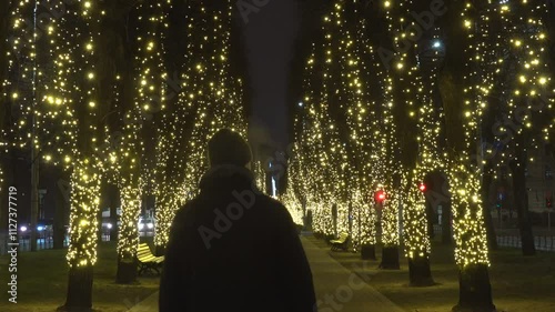 Riga, Latvia A man walks at night on a Christmas-decorated avenue in the center of town, Brīvības bulvāris