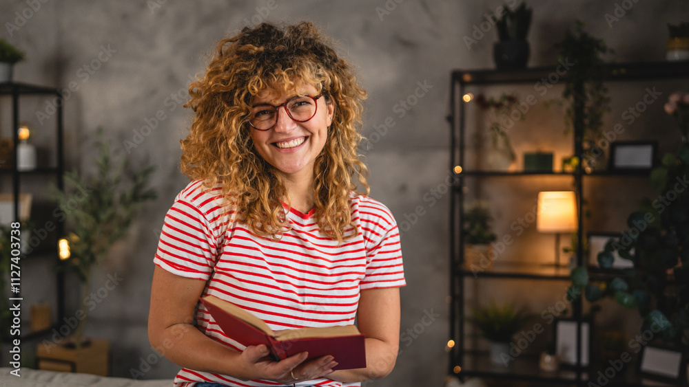 young adult woman with curly hair and eyeglasses read a book at home young adult woman with curly hair and eyeglasses read a book at home
