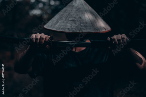 A samurai warrior in a mysterious forest unsheathes his katana sword, radiating strength and honor, preparing for an intense battle Close-up of a brave warrior unsheathes his katana in a dark forest. photo