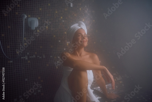 Photos Young woman with eyes closed relaxing in steam room in a Turkish bath
