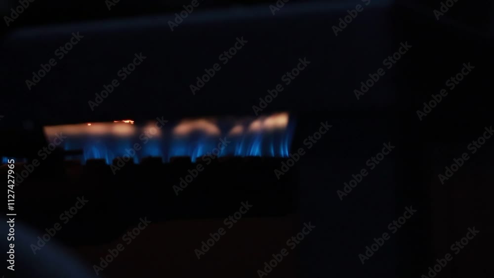 A close-up of a gas stove with vibrant blue and orange flames. The image captures the intense heat and energy of a burning gas. A close-up of a gas stove with vibrant blue and orange flames. The image captures the intense heat and energy of a burning gas.