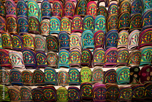 Venta de zapatillas de colores con bordados en el zoco de Marrakech, Marruecos.	 photo