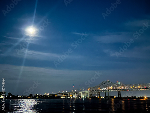 Moon over Mississippi River in front of busy bridge