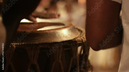 detail of hands playing leather timbal, percussion instrument in capoeira circle photo