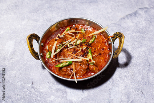 Mutton Karahi topped with ginger and green chilli served in karahi isolated on grey background side view of indian, bangladeshi and pakistani food photo