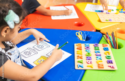 Latino boys and girls returning to class, coloring and learning about recycling.