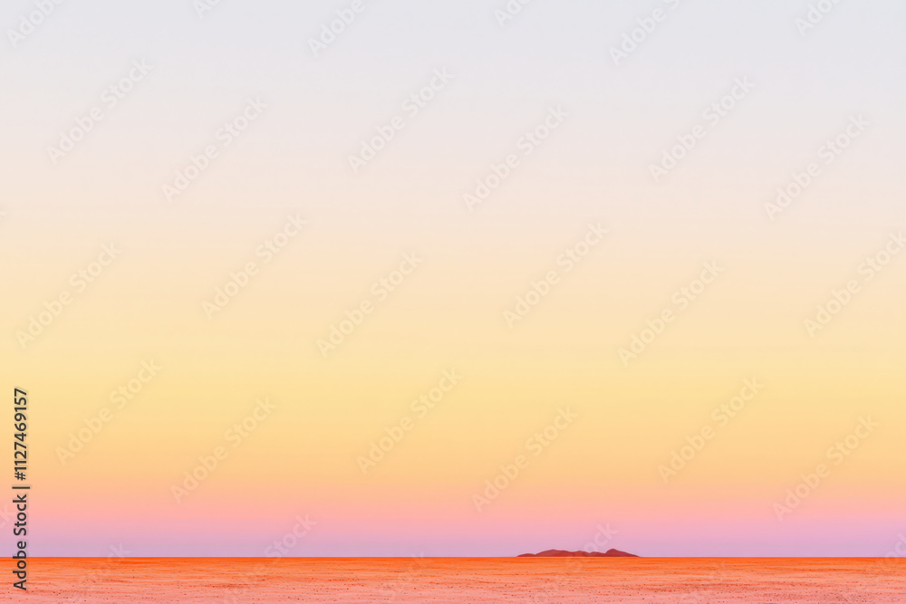 Fototapeta premium serene landscape featuring soft gradient of orange and pink hues transitioning into pale sky, evoking tranquility and calmness