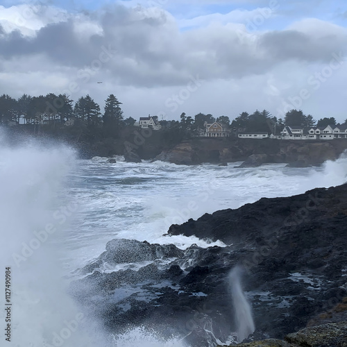 Depoe Bay Oregon during king tides,  photograph of big wave splashing onto retainer wall of tourist view point.  photo