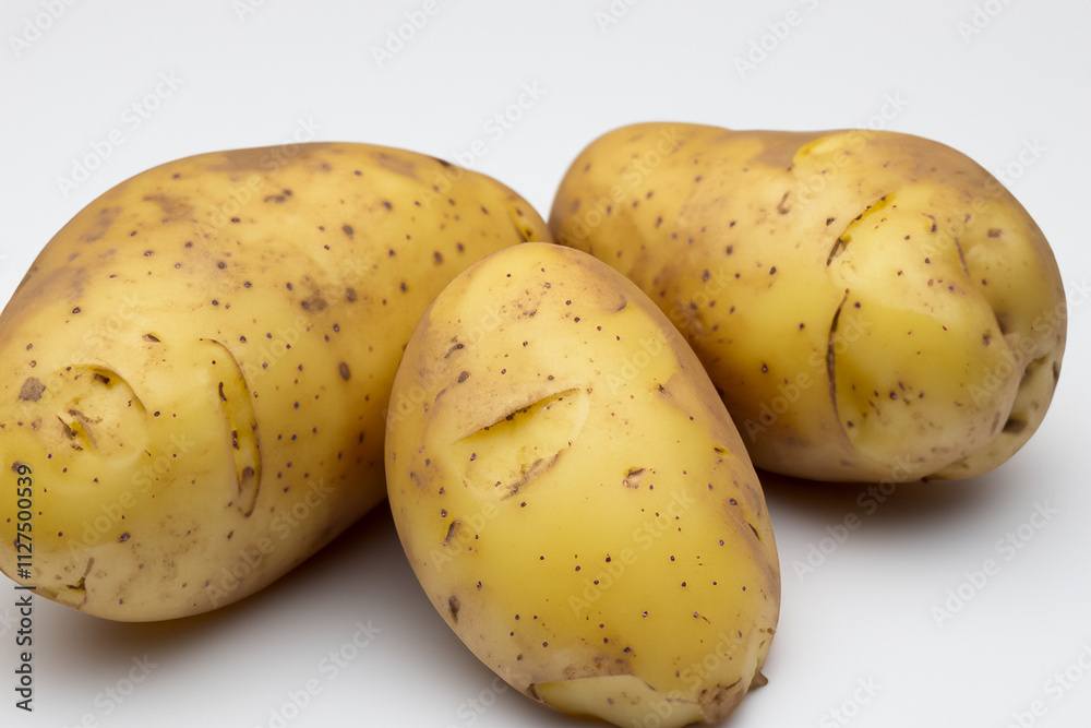 Potatoes on background. Plate of vegetables and potatoes on background. A white potato lies on a white background with vegetables. A white potato lying on a white background with vegetables lifestyle. Potatoes on background. Plate of vegetables and potatoes on background. A white potato lies on a white background with vegetables. A white potato lying on a white background with vegetables lifestyle.