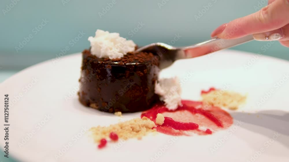 fork cutting delicious sweet chocolate cake on wooden table with natural light on morning