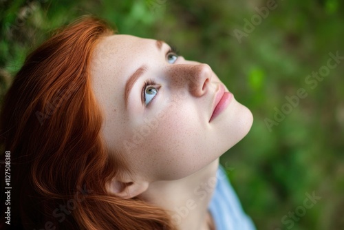 A woman with striking red hair looks up at the sky, lost in thought