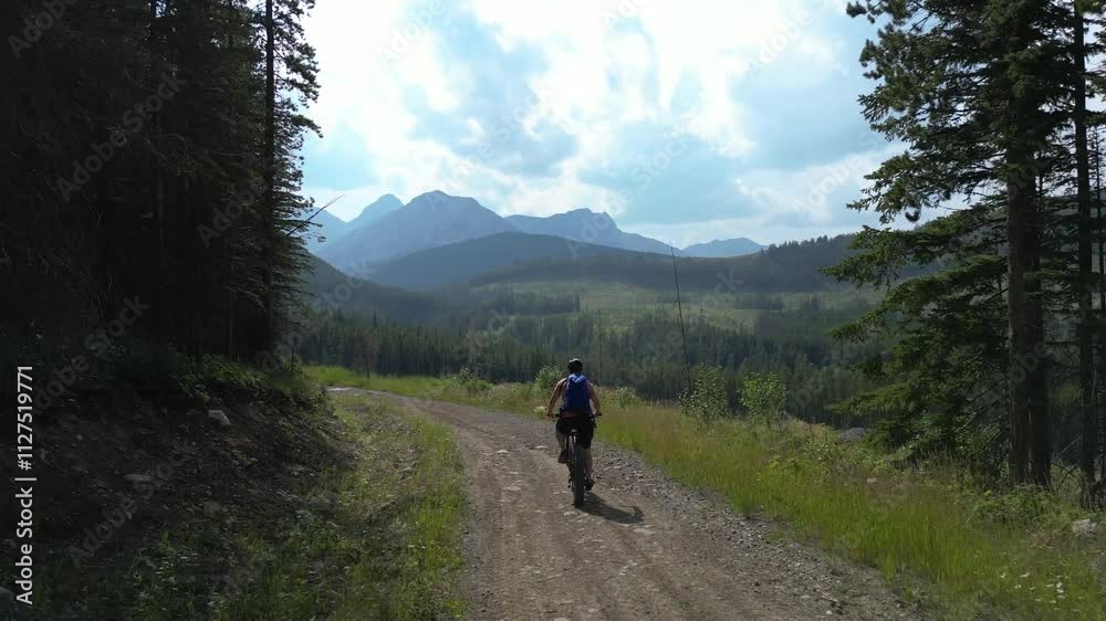 Man Mountain Biking on Gravel Road. Crowsnest Pass, AB, Canada. Man Mountain Biking on Gravel Road. Crowsnest Pass, AB, Canada.