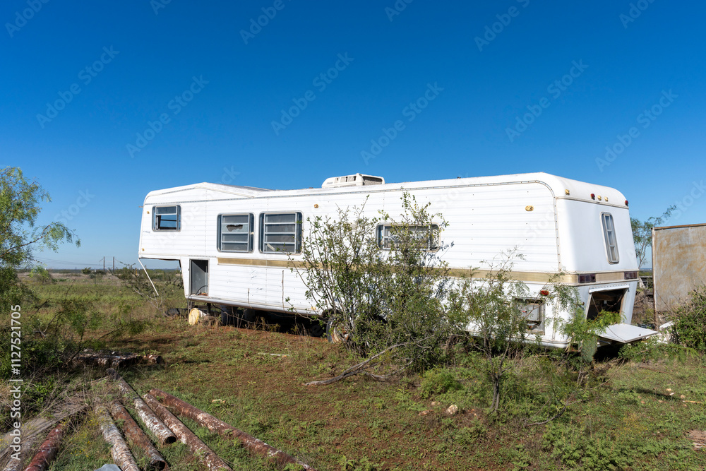 An old recreational vehicle abandoned in a Texas field An old recreational vehicle abandoned in a Texas field