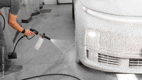Applying foam to a car at a car wash. Spraying foam onto a car with a spray bottle. Detergent