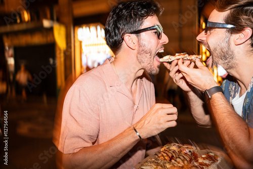 Gay couple sharing a delicious pizza at night photo