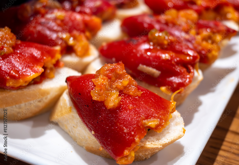 Typical snacks of Basque Country, pinchos or pinxtos skewers with small pieces of bread, fish, sea food, sweet green pepper served in bar in San-Sebastian or Bilbao, Spain Typical snacks of Basque Country, pinchos or pinxtos skewers with small pieces of bread, fish, sea food, sweet green pepper served in bar in San-Sebastian or Bilbao, Spain